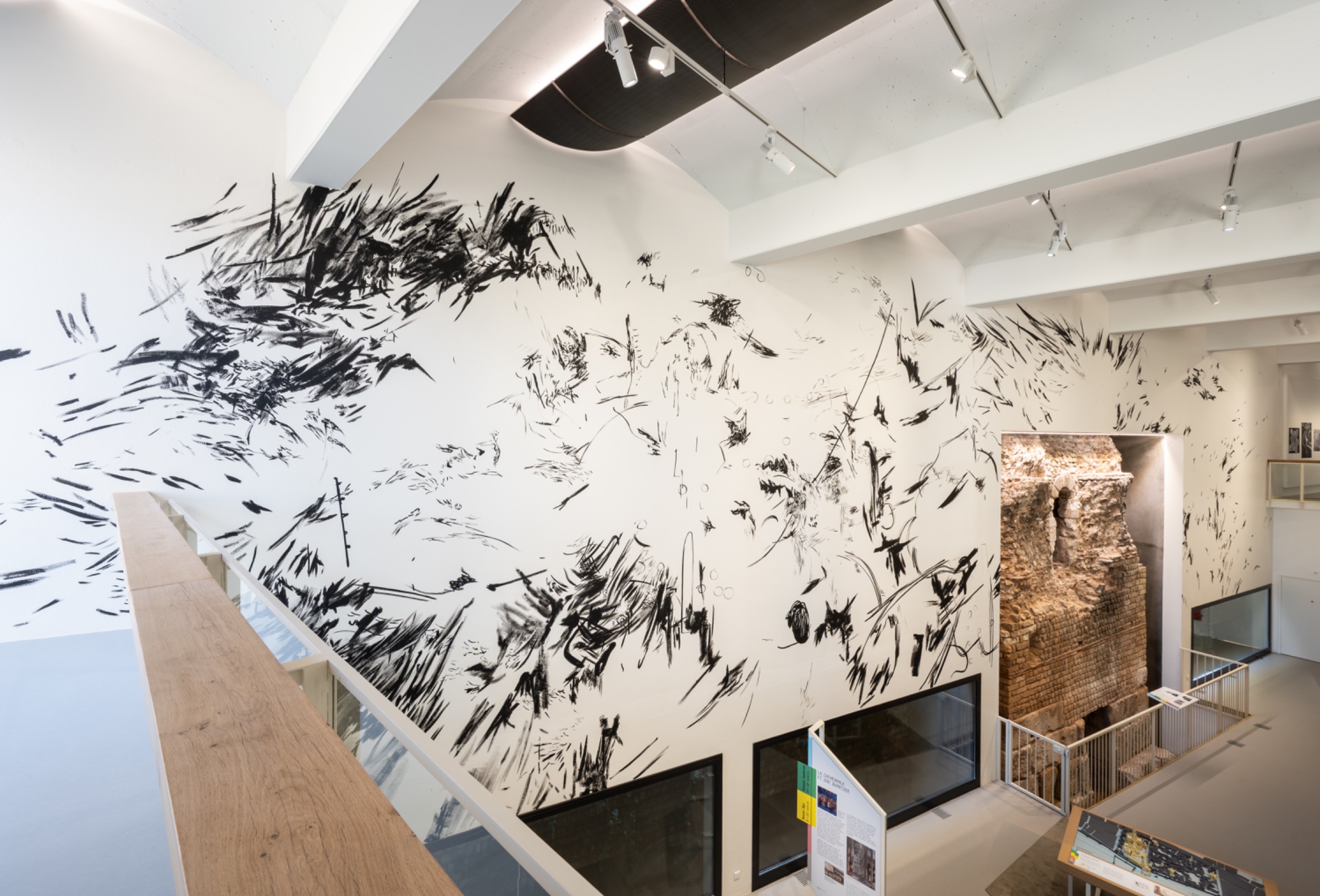 Mur décoré de lignes abstraites noires et blanches dans un espace lumineux.